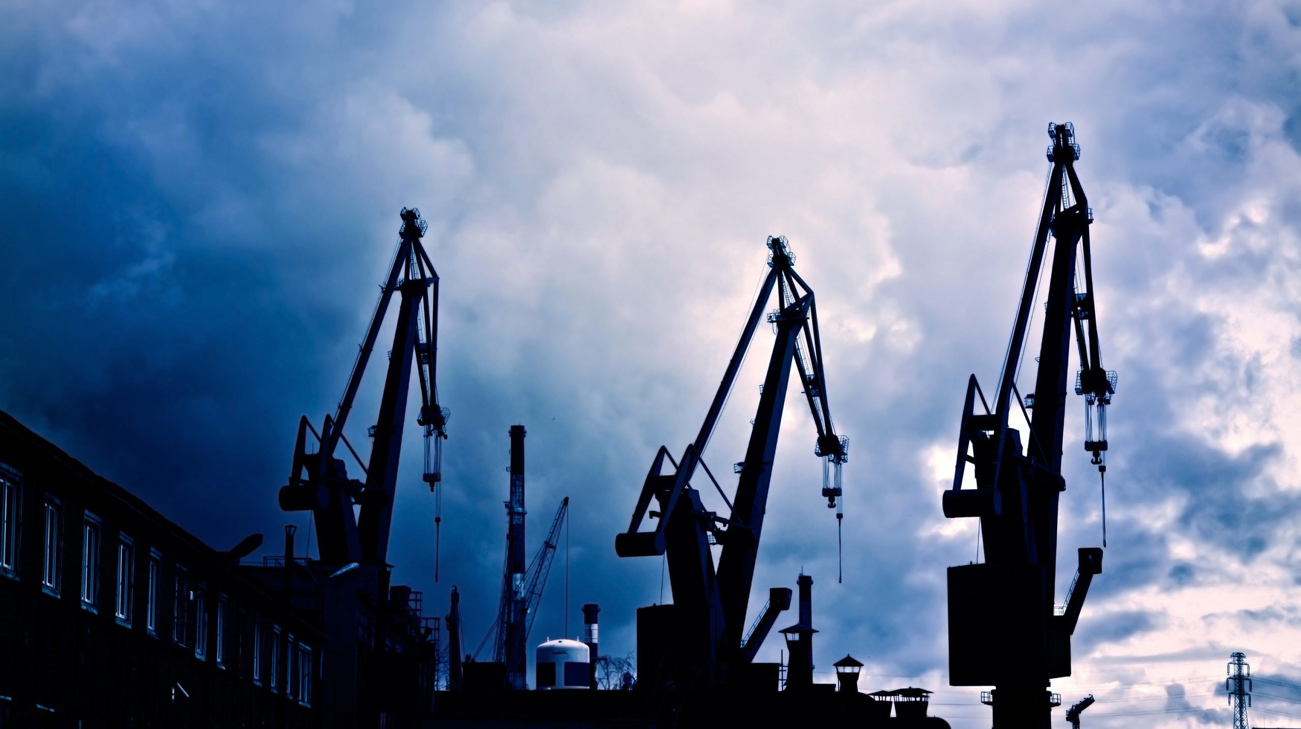 Industrial conceptual image. Industrial conceptual image. Dark and sullen clouds over industrial shipyard area with cranes.